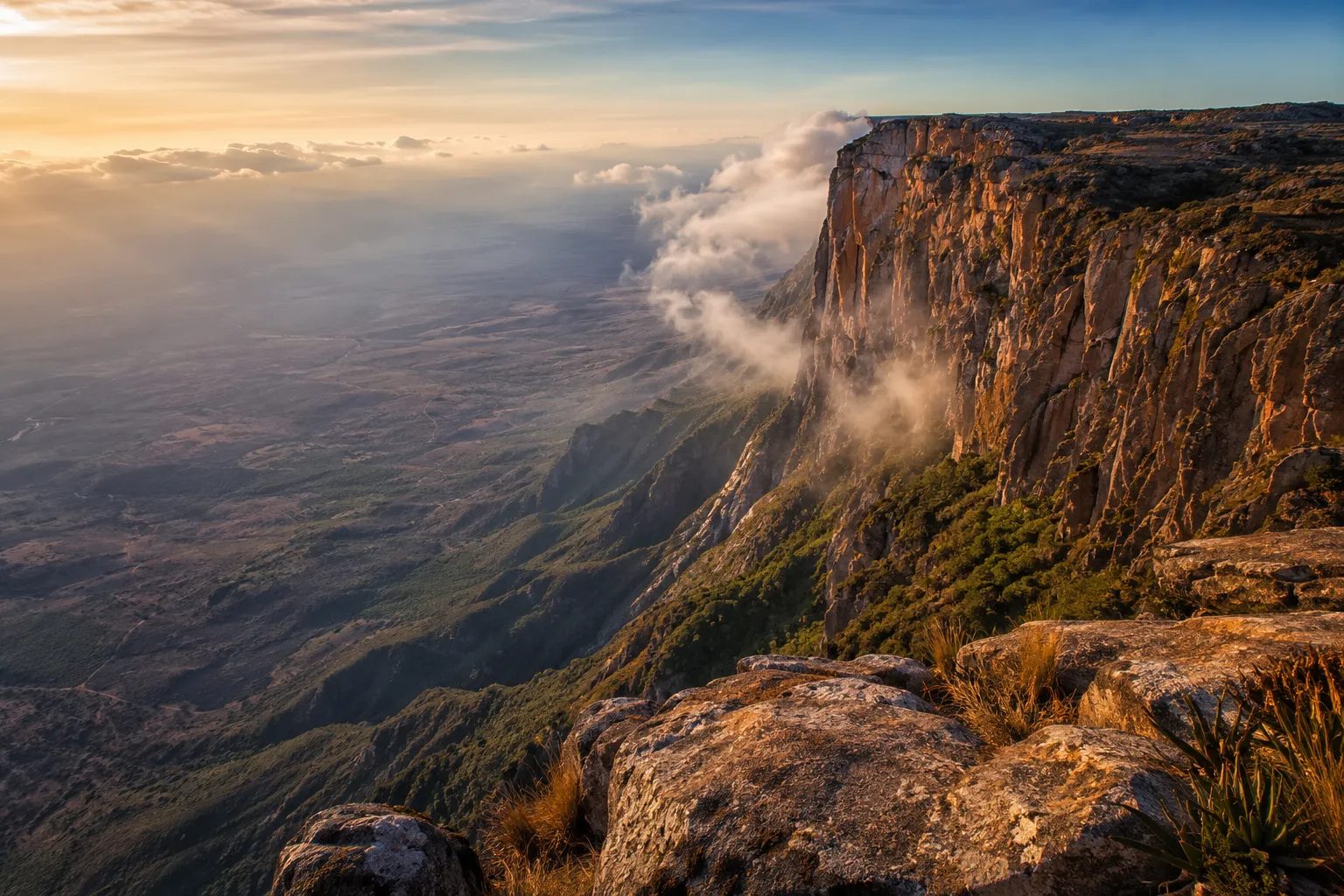 The Tundavala escarpment in Huila at golden hour, sheer cliffs dropping to the plains below